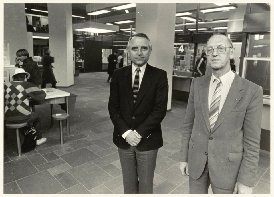 De scheidende postdirecteur Mr.J.J. van der Goes (rechts) en zijn opvolger J. de Boer in het postkantoor aan de Gedempte Oude Gracht. NL-HlmNHA 54013881