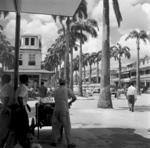 De Maagdenstraat in Paramaribo. Op de voorgrond een man met een drankkarretje, Bestanddeelnr 252-4924