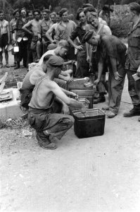 De maaltijd voor de militairen wordt in de mess tins geschept, Bestanddeelnr 1737