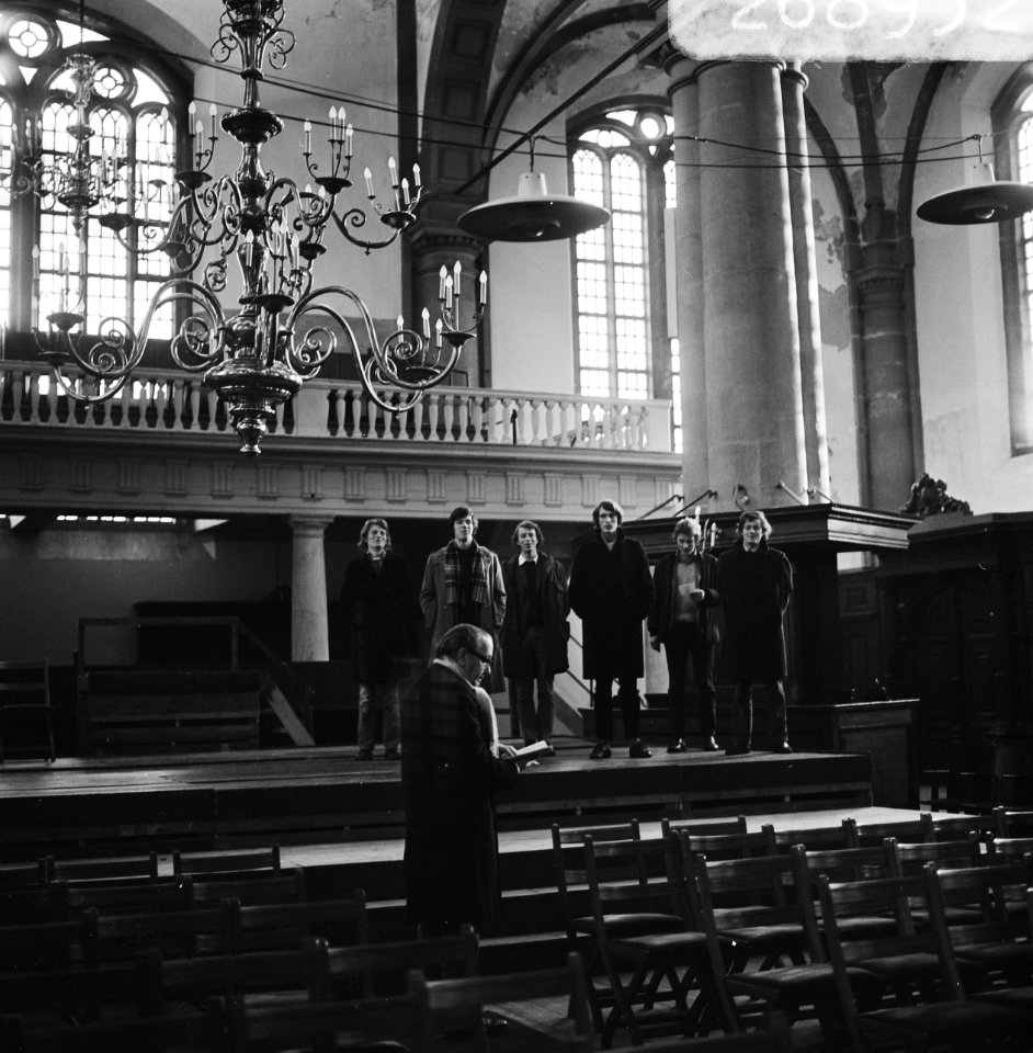 De regisseur met op de achtergrond de acteurs op het podium, Bestanddeelnr 926-8932