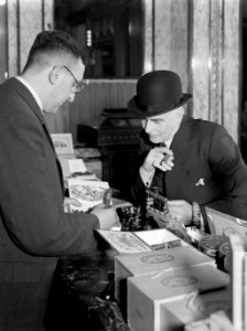 De winkelier adviseert de heer Nijman bij het kopen van sigaren, Bestanddeelnr 190-0680