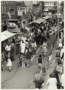 De zesde knoedelmarkt (jaarmarkt) in de Amsterdamstraat, nabij de Zuidpolderstraat, ziende naar het noorden. NL-HlmNHA 54010051