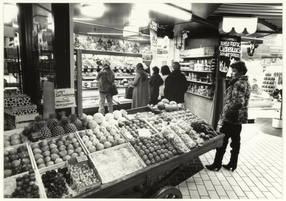 De winkel van de Fa. C.J. IJzelenburg in groente, fruit en delicatessen in de kelder van de Brinkmann-passage. NL-HlmNHA 54015593