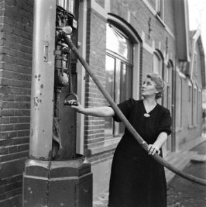 De vrouw van garagehouder Willem Smienk bij haar woning aan de Dorpsstraat, Bestanddeelnr 901-0010