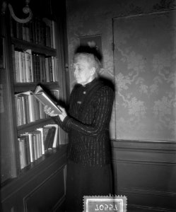 De schrijfster bij een boekenkast, Bestanddeelnr 907-0557