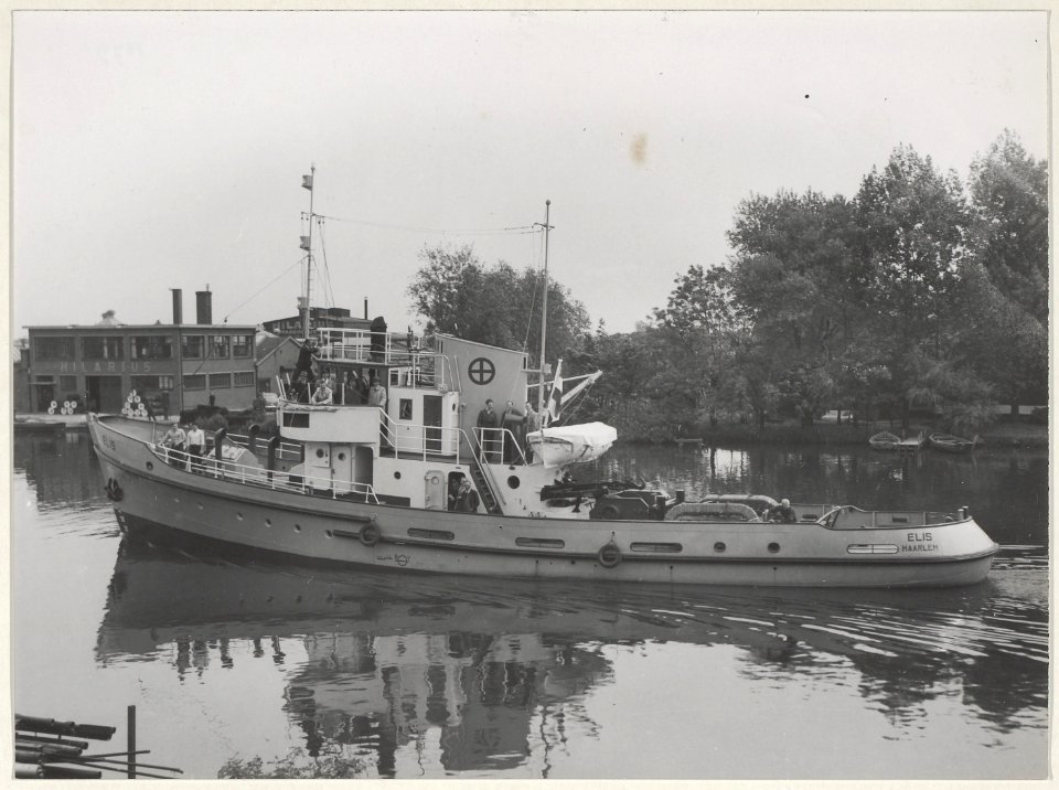 De sleepboot Elis uit Haarlem in het Noorder Buiten Spaarne bij de fabriek van Hilarius. NL-HlmNHA 54010790