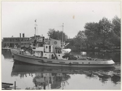 De sleepboot Elis uit Haarlem in het Noorder Buiten Spaarne bij de fabriek van Hilarius. NL-HlmNHA 54010790