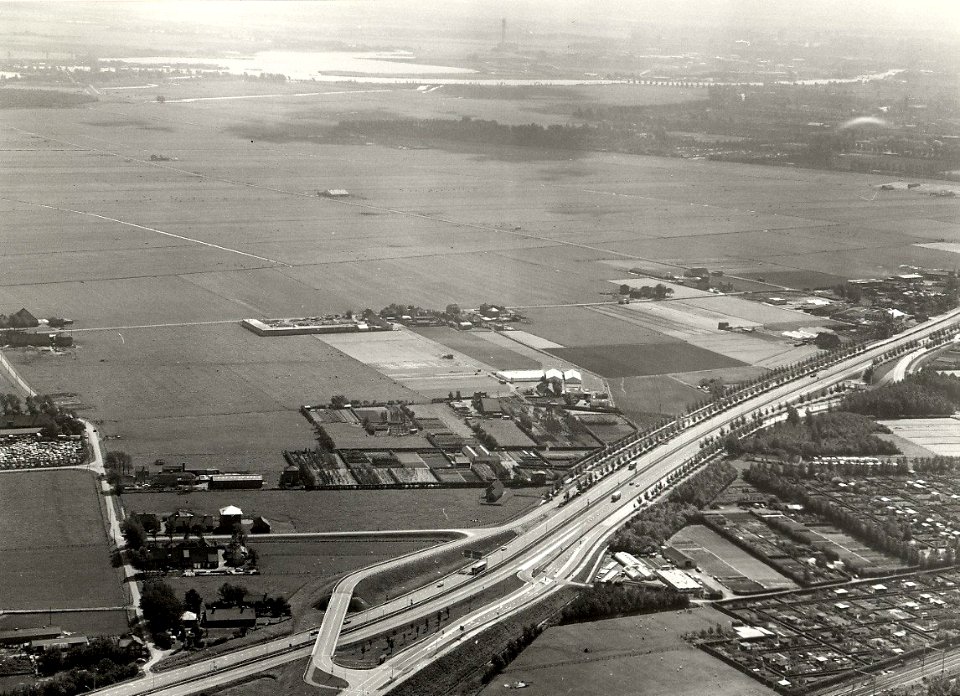 De Velserbroekpolder vanuit de lucht gezien rechts onder Rijksweg 4 naar de Velsertunnel. Aangekocht in 1978 van fotograaf C. de Boer. Identificatienummer 54-005666, NL-HlmNHA 54005666
