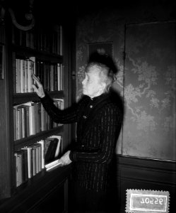 De schrijfster bij een boekenkast, Bestanddeelnr 907-0556