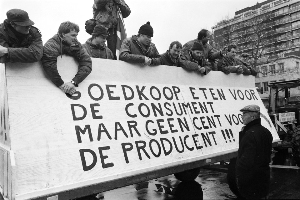 Demonstrerende boeren hangen aan een trekker met tekst op spandoek, Bestanddeelnr 934-4126