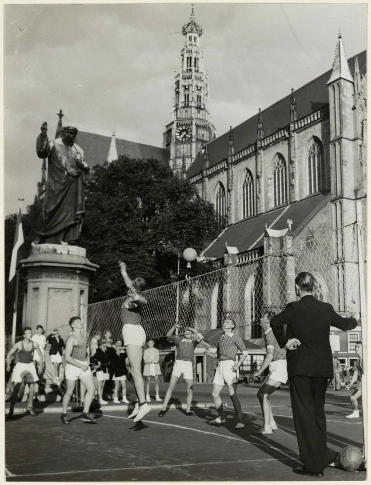 Demonstratie van volleybal door een jeugdteam naast het standbeeld van Laurens Jansz. Coster. NL-HlmNHA 54004513