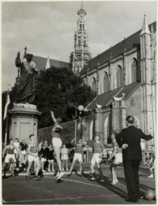 Demonstratie van volleybal door een jeugdteam naast het standbeeld van Laurens Jansz. Coster. NL-HlmNHA 54004513