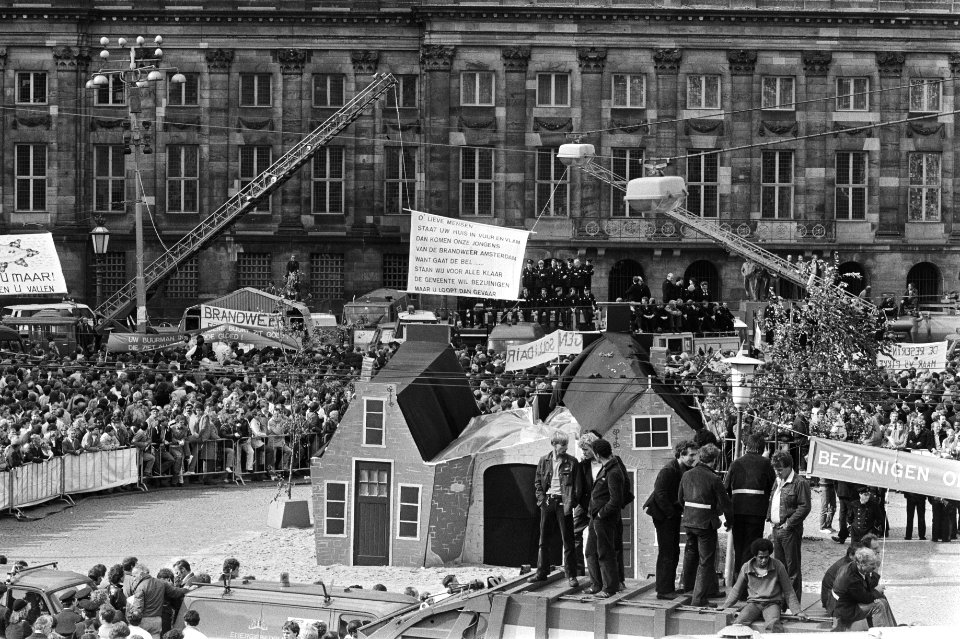 Demonstratie voor het paleis op de Dam met huizen die in brand gestoken gaan wor, Bestanddeelnr 932-7235