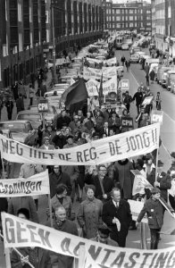 Demonstranten trekken met vlaggen en spandoeken door de straten van Amsterdam, Bestanddeelnr 924-4002