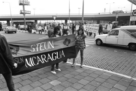 Demonstranten tegen de reis met spandoek Steun Nicaragua, Bestanddeelnr 932-6091