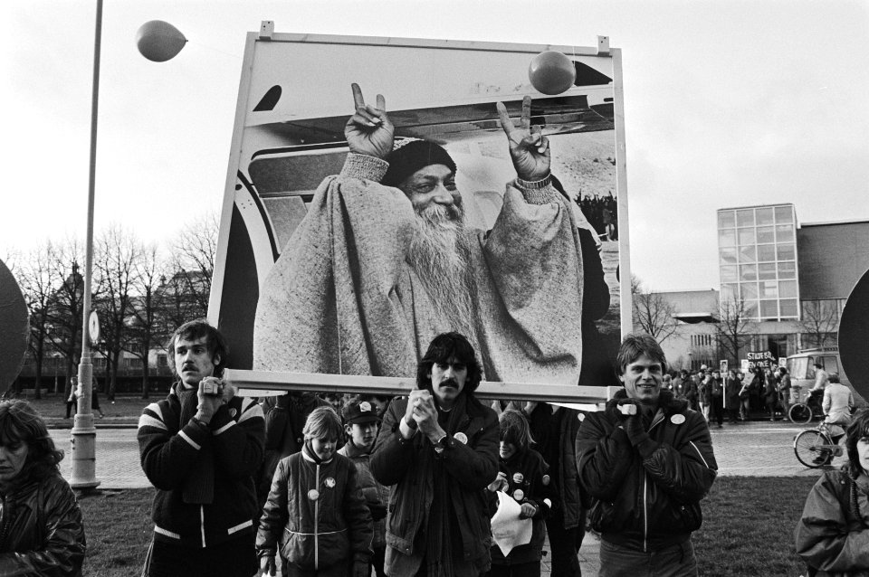Demonstranten dragen een portret van leider Baghwan Shree Rajneesh, Bestanddeelnr 932-4720