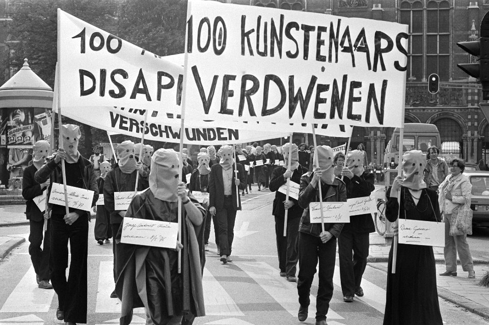 Demonstranten in Amsterdam, met kappen op, voeren in optocht spandoeken en borde, Bestanddeelnr 931-6768