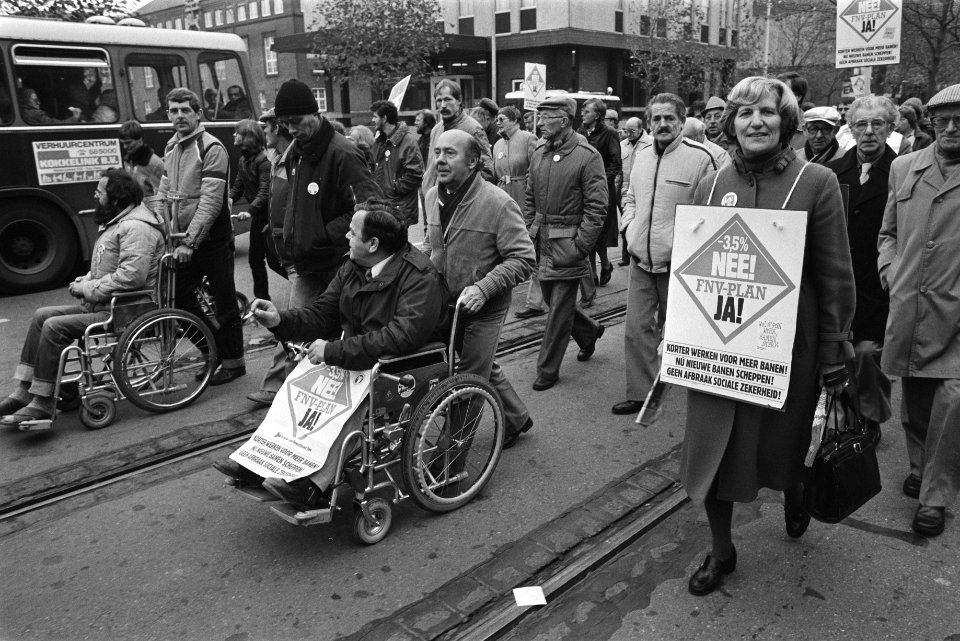 Demonstranten, waaronder mensen in rolstoel, lopen door de stad, Bestanddeelnr 932-7805