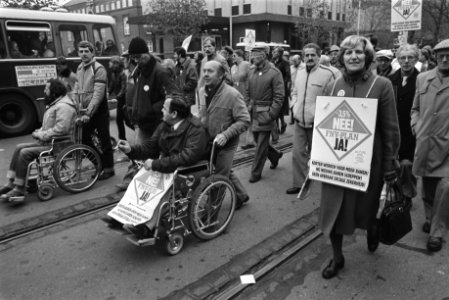 Demonstranten, waaronder mensen in rolstoel, lopen door de stad, Bestanddeelnr 932-7805