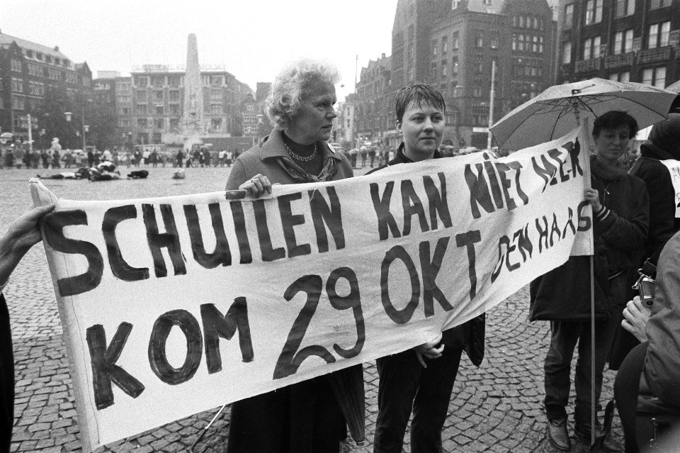 Demonstranten met spandoek Schuilen kan niet meer, kom 29 okt Den Haag links , Bestanddeelnr 932-7197