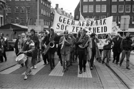Demonstranten met muziekinstrumenten en spandoek Geen afbraak sociale zekerheid, Bestanddeelnr 932-7800