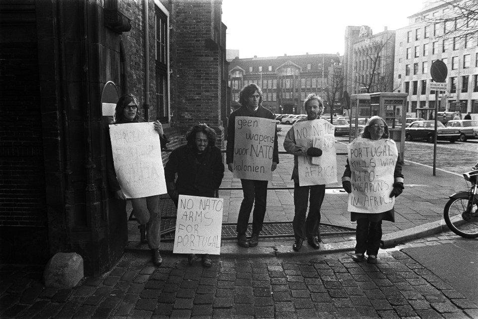 Demonstranten met borden tegen NATO-vergadering voor toegangspoort Binnenhof Den, Bestanddeelnr 923-9992