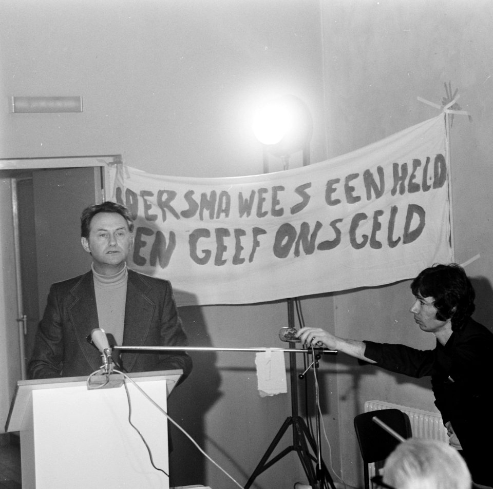 De minister tijdens zijn toespraak, achter hem wordt een spandoek opgehouden, Bestanddeelnr 926-7878