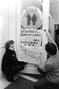 De bezetters plakken een pamflet onder het CDA-symbool, Bestanddeelnr 932-8437