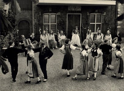 De bloemenkoningin op het binnenplein van de Kloveniersdoelen, waar een dansproep uit het Zwitserse Bern een voorstelling gaf, 2 augustus '48. Aangekocht in 1976 van fotograaf C. de Boer bv., NL-HlmNHA 54010538