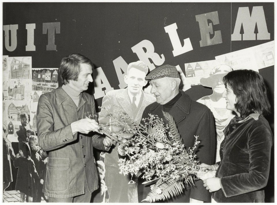 De 20.000ste bezoeker , de heer L.Koper, bij de tentoonstelling Groeten uit Haarlem. Links Ferry Welbergen en rechts Clara Brinkgreve. NL-HlmNHA 54036622