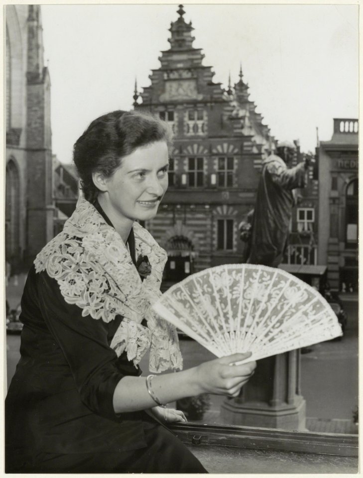 Dame toont kantwerk op een expositie in restaurant Brinkman met uitzicht op de Vleeshal. NL-HlmNHA 54005659