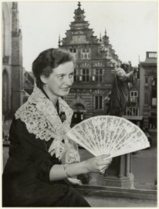 Dame toont kantwerk op een expositie in restaurant Brinkman met uitzicht op de Vleeshal. NL-HlmNHA 54005659