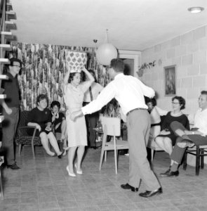 Dansende gastvrouw met een van de gasten terwijl ze een vaas op haar hoofd houdt, Bestanddeelnr 255-4331
