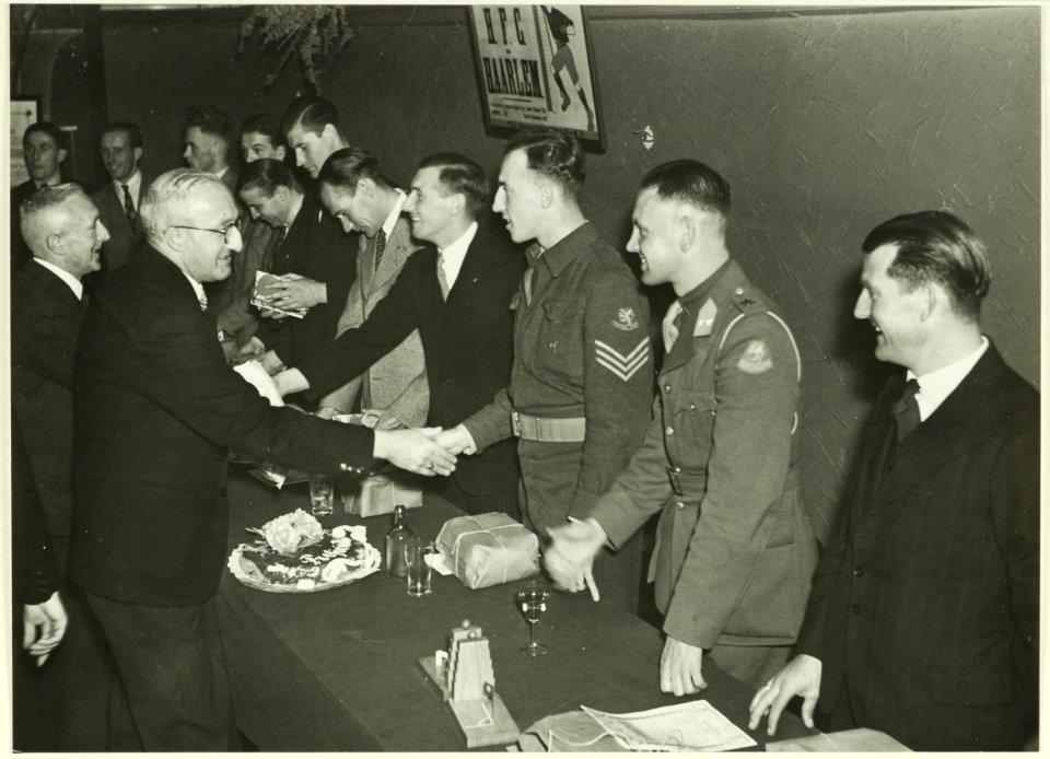 De heer P. Langeveld van de H.V.B. overhandigt de spelers van de HFC Haarlem, na het behalen van het afdelingskampioenschap, een doos zeep. Achter van links naar rechts Bert Boeree, Jan van, NL-HlmNHA 5400466219