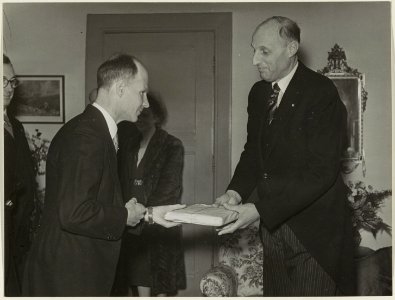 De heer R. Burdet biedt de burgemeester van Bloemendaal Jhr. Mr. den Tex een geschenk aan t.g.v. zijn zilveren ambtsjubileum. NL-HlmNHA 54004126