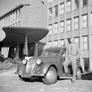 De heer de Visser staand voor zijn Simca 8 voor het KLM hoofdgebouw in Den Haag, Bestanddeelnr 255-8953
