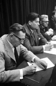 De heer Hendrik Koekoek (BP) maakt aantekeningen, rechts de heren E.J. Harmsen (, Bestanddeelnr 919-6667