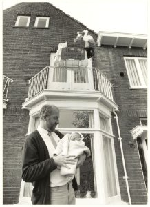 De heer Lamberts met de pasgeboren baby. Middenweg 73, NL-HlmNHA 54015524