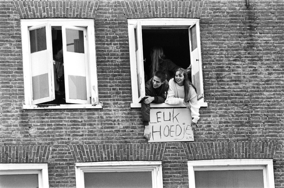 De koninklijke familie bezoekt Harlingen. Uit het raam hangen twee personen met , Bestanddeelnr 932-1322
