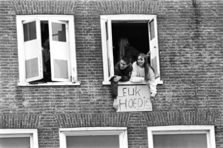 De koninklijke familie bezoekt Harlingen. Uit het raam hangen twee personen met , Bestanddeelnr 932-1322