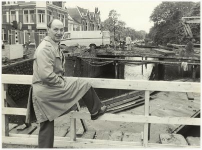De heer de Jong van Openbare Werken op de noodbrug t.b.v. de bouw van de (nieuwe) Kleine Houtbrug, ziende naar het westen. NL-HlmNHA 54025803