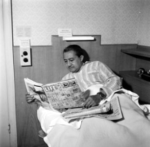 De kunstenaar Eppo Doeve leest kranten in bed van het Green Park Hotel in Londen, Bestanddeelnr 254-2909