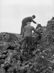 De journaliste Anita Joachim en de gids Jonsson beklimmen een lavarots, Bestanddeelnr 190-0493