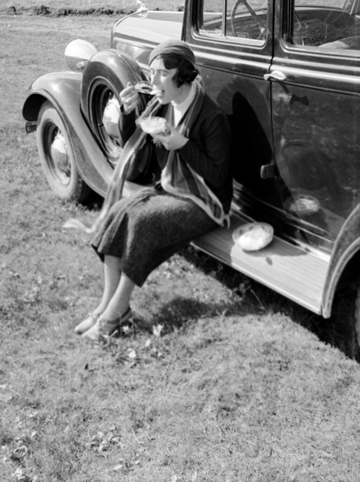 De journaliste Anita Joachim aan de maaltijd op de treeplank van een auto tijden, Bestanddeelnr 190-0496