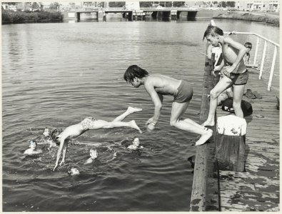 De jeugd aan het zwemmen in het Zuider Buiten Spaarne bij de Buitenrustbrug, ziende naar het noorden. NL-HlmNHA 54012088