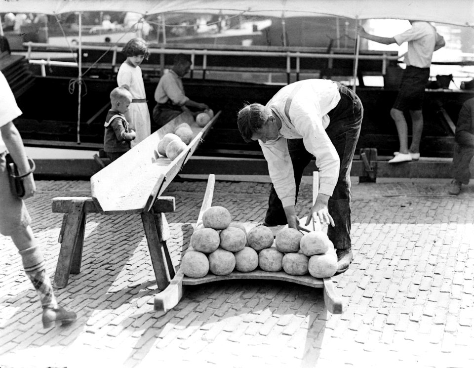 De Kaasmarkt in Alkmaar - man legt kazen in een goot die naar een schip voert, Bestanddeelnr 252-0755