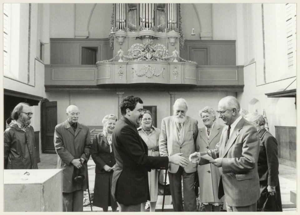 De heer van Dortmond (rechts) overhandigt een cheque van dertigduizend gulden aan kerkvoogd van de Bult voor electra in de Waalse Kerk. NL-HlmNHA 54013217
