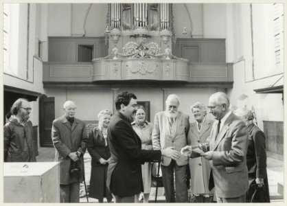 De heer van Dortmond (rechts) overhandigt een cheque van dertigduizend gulden aan kerkvoogd van de Bult voor electra in de Waalse Kerk. NL-HlmNHA 54013217