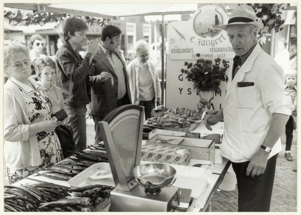 De marktkraam van vishandelaar Piet Jongert is door collegae versierd, omdat Piet al 45 jaar ononderbroken wekelijks van Monnickendam naar Haarlem komt. NL-HlmNHA 54005143
