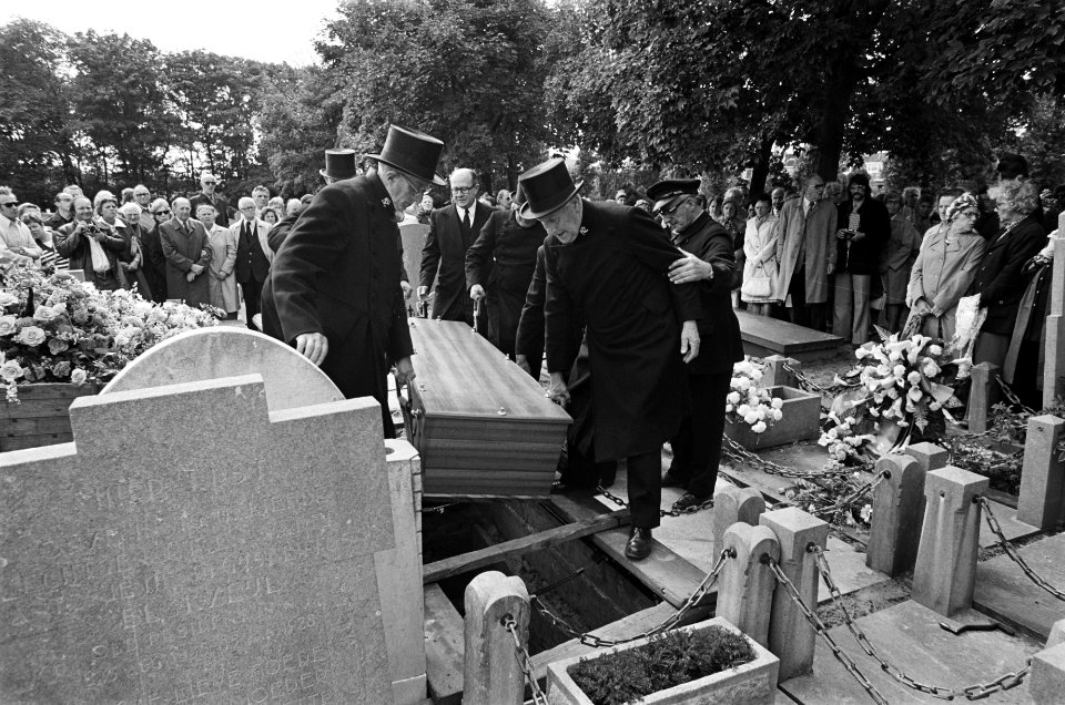 De kist van Fie wordt in het graf getild onder het oog van de rouwende familie, Bestanddeelnr 928-0672